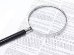 Magnifying glass lying on a legal contract